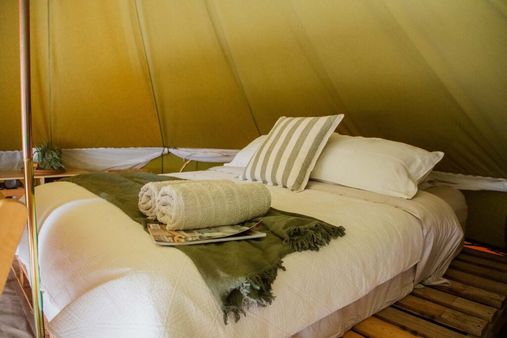 Double bed inside a furnished glamping tent at Outback Almonds