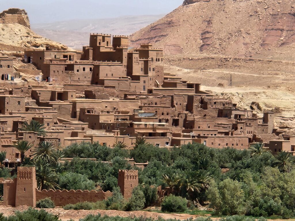 Traditional earthen buildings clustered against a rocky hillside in Morocco