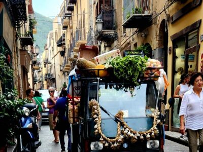Vegetable-laden vehicle on a narrow street in Sicily