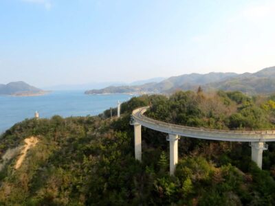 Elevated Shimanami Kaido cycleway curving above wooded islands and the Seto Inland Sea