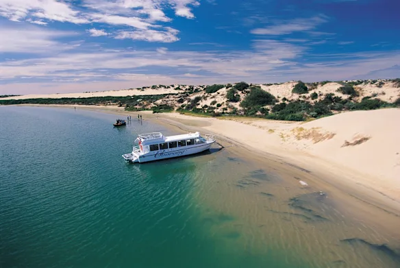 Spirit of the Coorong cruise boat beside pale coastal dunes